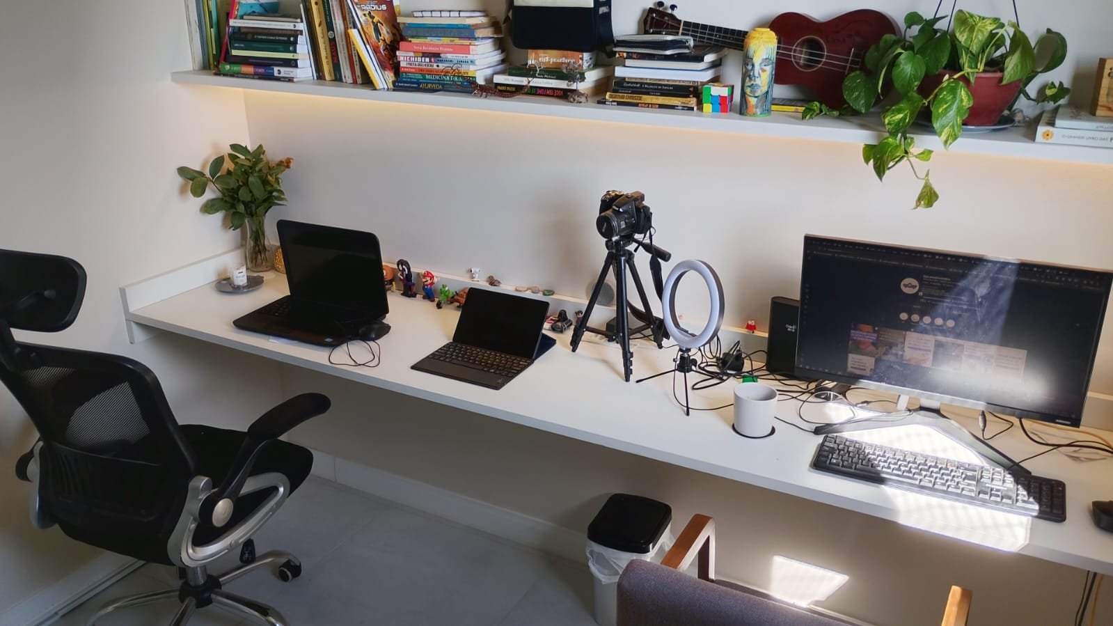 Estúdio BYÁ durante o dia com iluminação natural, bancada de trabalho com equipamentos de produção